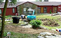 One challenge presented by the client was to replace the front lawn with a combination of plant materials that would vary in color and texture throughout the year and the creation of a water feature that could be enjoyed from inside the home.