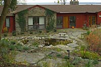 A terrace created out of a single slab of stone provides a vantage point from which to view the waterfalls and pond below.